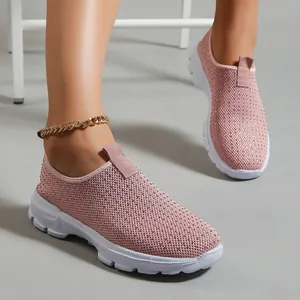 Dettaglio di sneaker rosa traspiranti in maglia fly-knit indossate con suola bianca