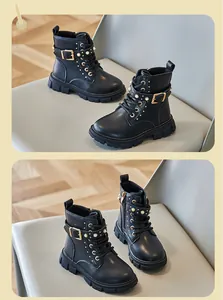 Close-up of black girls' Martin boots with decorative pearl studs and buckles.
