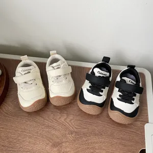 Detailed view of baby walking shoes with soft soles in beige and black-white styles.