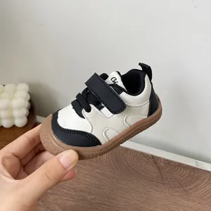 Detailed macro view of infant soft sole walking shoe with black and white leather finish