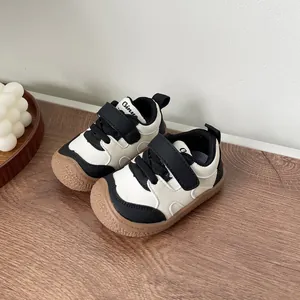 Detailed macro view of black and white baby walking shoes featuring soft rubber soles.