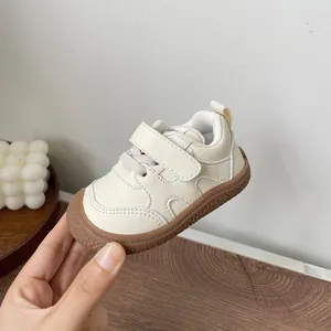 Close-up of cream baby soft sole walking shoes with velcro strap and brown rubber sole