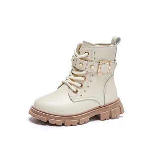 Elegant beige children's Martin boots with pearl buckle, studs, and chunky lug sole.