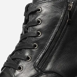 Close-up detail showing the premium leather texture, side zipper, and laces of black Martin boots