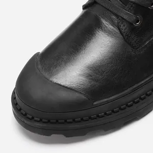Close-up detail of black genuine leather Martin boot with reinforced rubber toe cap