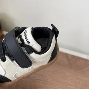 Close-up of black and white baby walking shoe with velcro strap and soft rubber sole