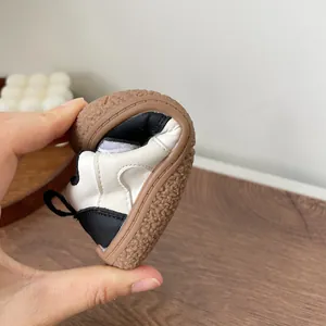 Flexible soft sole infant walking shoes demonstrated by bending for toddler comfort