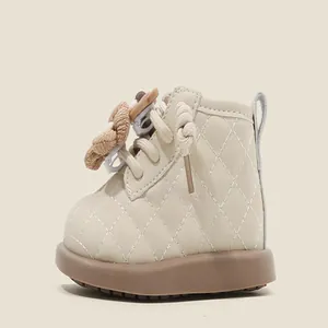 Vue détaillée d'une bottine en cuir matelassé beige pour bébé avec fleur décorative