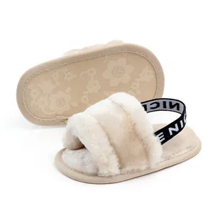 Primer plano de sandalias de pelo beige para bebé con suela suave antideslizante.