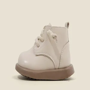 Side view of cream faux leather toddler walking boots featuring thick durable brown soles