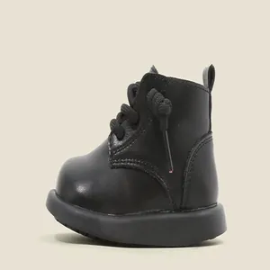 Side view detail of black toddler leather boots with thick rubber soles.