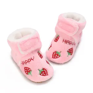 Close-up detail of soft pink plush baby walking boots featuring cute strawberry embroidery