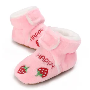 Detailed view of soft pink plush baby toddler boots with strawberry and HAPPY embroidery.