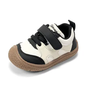 Classic black and white toddler walking shoes featuring soft soles and adjustable Velcro straps