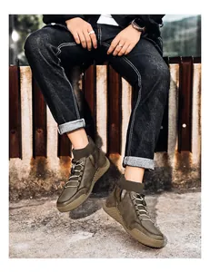 Detailed outdoor shot of men's British style olive green sock-cuff Martin boots on feet