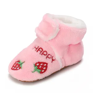 Macro view of pink baby walking shoe featuring cute strawberry and HAPPY embroidery details.