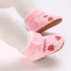 Close-up of pink baby plush boots with cute strawberry embroidery and soft anti-slip sole.