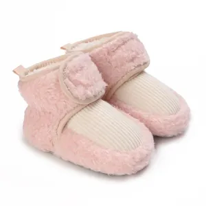 Cozy pink plush baby winter boots with cream ribbed toe and velcro strap details.
