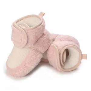 Detailed close-up of soft pink fluffy baby winter boots showing warm white lining