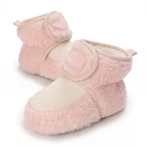 Detailed view of pink fuzzy infant walking boots with soft white fleece lining and strap