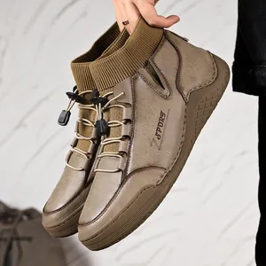 Macro view of men's casual brown leather boots featuring a ribbed knit sock ankle collar