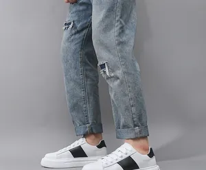 Detailansicht weißer Herren-Sneaker mit schwarzem Streifen und dicker profilierter Sohle.