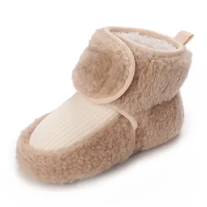 Close-up of a plush beige baby winter boot with soft fleece lining and velcro closure.