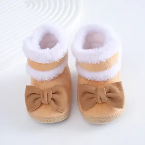 Detaillierte Nahaufnahme weicher warmer Babystiefel mit braunen Schleifen und Pelz