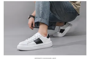 Weiße Plateau-Sneaker für Herren mit schwarzen Streifen am Fuß eines Models gezeigt