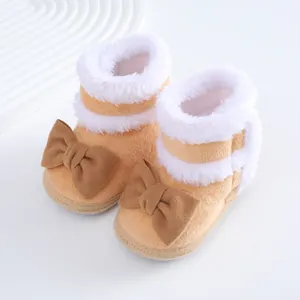 Detailansicht warmer Baby-Plüschstiefel mit hübschen braunen Schleifen und weißem Kunstpelz