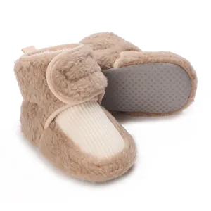 Close-up of beige plush baby winter boots with non-slip soft soles and fleece lining