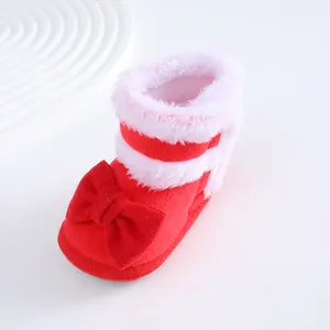 Roter Neugeborenen-Babyschuh mit großer Schleife und weißem Kunstfellbesatz