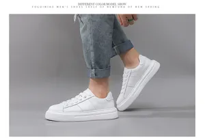 Nahaufnahme von weißen Herren-Plateau-Sneakern kombiniert mit lässigen blauen Jeans.