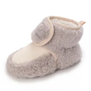 Detailed macro shot of grey plush baby bootie featuring warm fleece lining and Velcro strap