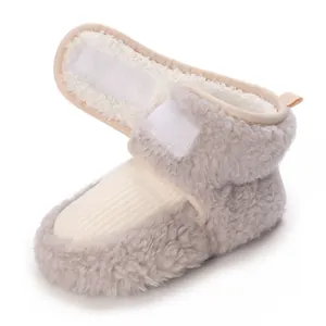 Close-up detail of soft fleece baby winter booties with adjustable hook and loop strap