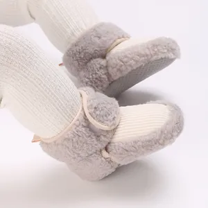 Close-up of cozy fleece-lined baby booties with non-slip soft soles in cream and grey.