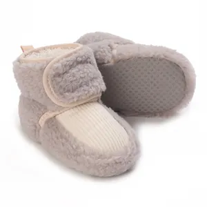 Close-up of grey fuzzy baby winter boots with anti-slip soft soles and velcro strap