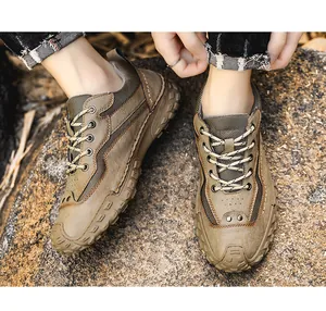 Gros plan de chaussures de randonnée marron pour hommes sur une surface rocheuse naturelle