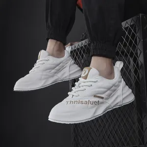Dettaglio di sneaker da uomo in pelle bianca con motivo trapuntato su fondo a griglia