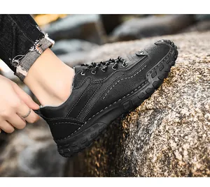 Détail de chaussures de loisirs d'extérieur pour hommes cousues main sur un rocher