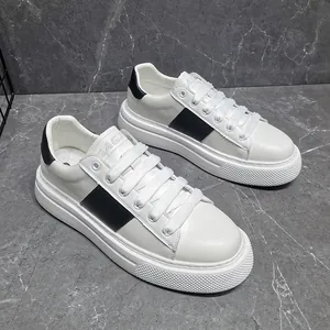 Weiße klobige Plateau-Sneaker mit schwarzem Seitenstreifen auf elegantem Marmor