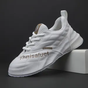 Dettaglio della sneaker in pelle bianca con trama trapuntata e marchio Thnisaluet laterale.