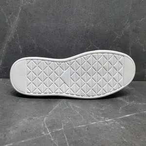 Detailansicht der weißen Schuhsohle mit rutschfestem Rautenmuster und dicker Schaumstoffbasis.