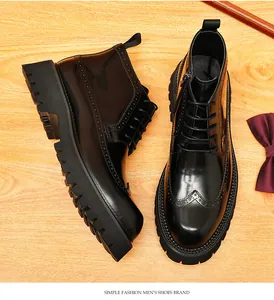 Detailed view of black shiny leather brogue boots with thick soles and side zippers.