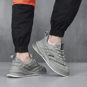 Dettaglio ravvicinato di sneaker casual in pelle trapuntata grigia da uomo con suola bianca