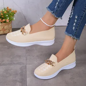 Détail de mocassins en maille beige pour femme avec boucle chaîne dorée et semelle
