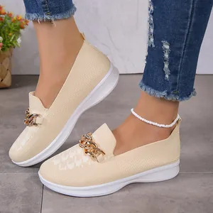 Gros plan sur des mocassins en maille beige respirants avec une chaîne décorative dorée chic