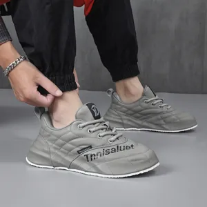 Vista dettagliata delle sneakers sportive da uomo in pelle grigia con cuciture trapuntate