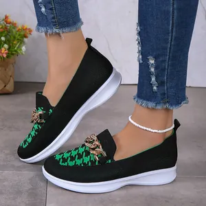 Gros plan de mocassins en maille pour femmes avec motif pied-de-poule et chaîne dorée.