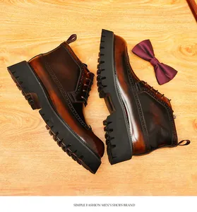 Detailed view of brown leather brogue boots with black lug soles and wingtip carving